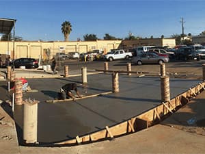 Professional construction crew pouring and finishing a concrete foundation Construction crew pouring and finishing concrete foundation