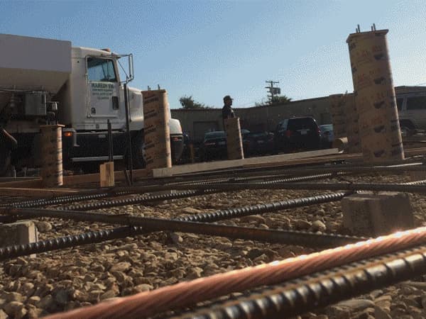 Building foundation reinforcement with rebar and concrete pillars Rebar and concrete pillars prepared for a building foundation